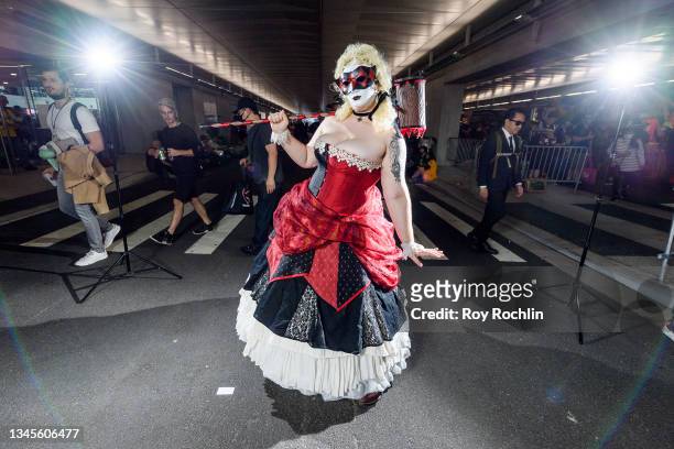Cosplayer dressed as a mashup between Harley Quinn and The Queen of Hearts from "Alice in Wonderland" poses during the second day of Comic Con at...