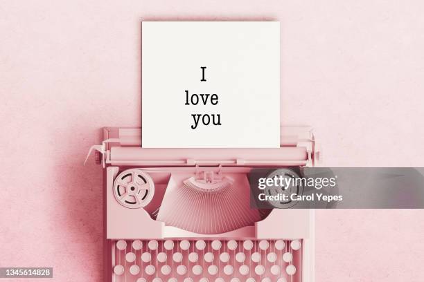 directly above pink pastel old typewriter with ii love you text written on paper - love you stockfoto's en -beelden