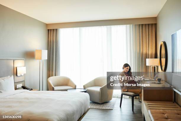 smiling entrepreneur using mobile phone in hotel - habitación de hotel fotografías e imágenes de stock