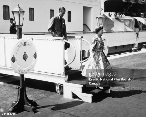 View of Queen Elizabeth II and Prince Philip, Duke of Edinburgh, as they disembark the Royal Yacht Britannia during their voyage to inland Canada on...