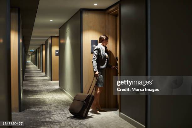 businesswoman with suitcase arriving in hotel - hyatt hotels corp hotel ahead of earnings figures stockfoto's en -beelden