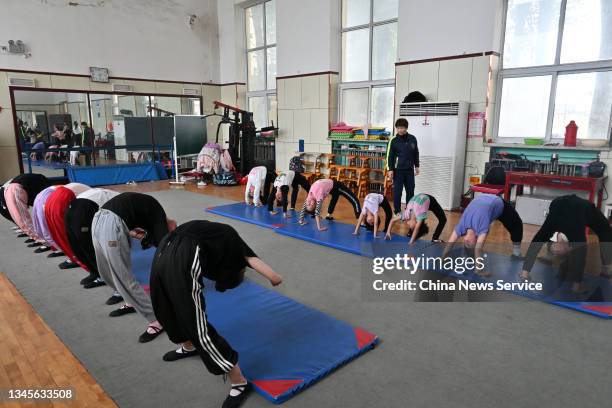 Students practise the basic skills of acrobatics at Wuqiao Acrobatic Art School on October 8, 2021 in Wuqiao County, Cangzhou City, Hebei Province of...
