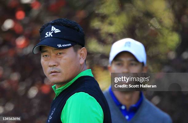 Choi of South Korea watches his tee shot on the second hole as Tiger Woods looks onduring the second round of the Chevron World Challenge at Sherwood...
