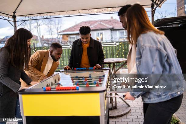 freunde spielen kicker und haben spaß - fastfood restaurant table stock-fotos und bilder