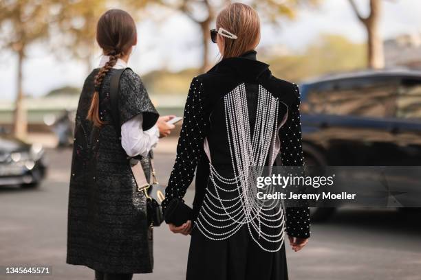 Fashion Week Guests wearing black vest and white blouse and a black jacket outside Giambattista Valli Show on October 04, 2021 in Paris, France.