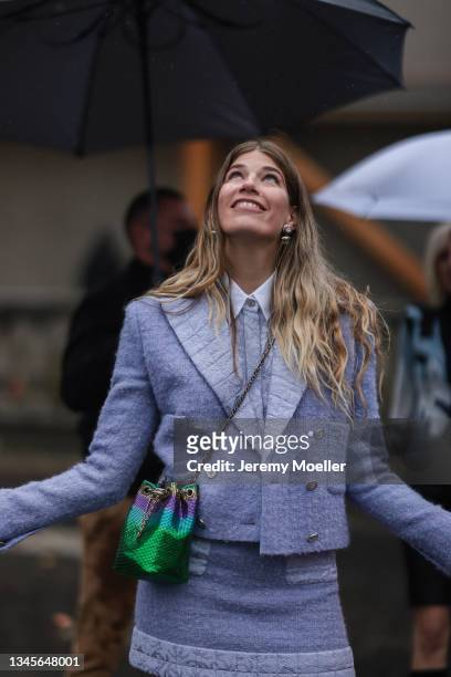 Veronika Heilbrunner wearing a blue blazer, a blouse and a skirt and a green bag on outside Chanel October 05, 2021 in Paris, France.