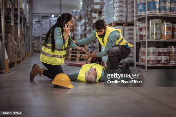 trabajadores de almacén después de un accidente en un almacén - sin sentido fotografías e imágenes de stock