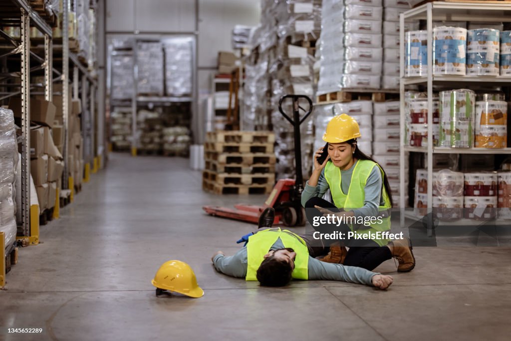 Worker Call an ambulance after warehouse manager lying down on warehouse floor