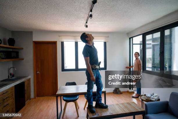 electrician fixing a broken light at a house - spoil system 個照片及圖片檔