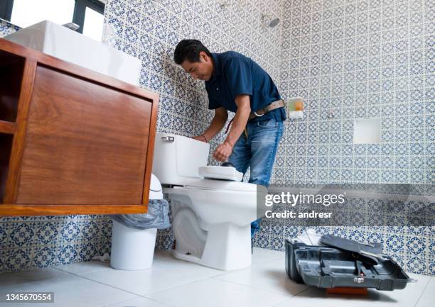 バスルームでトイレを固定するラテンアメリカの配管工 - 配管工 ストックフォトと画像