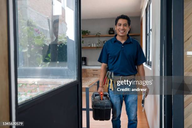 happy plumber or electrician arriving home after a house call - plumber man stockfoto's en -beelden