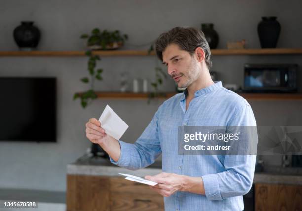 homme heureux à la maison vérifiant les lettres dans le courrier - courrier photos et images de collection