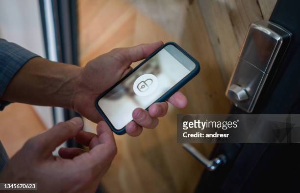 man opening the door of his house using a home automation system - safety bildbanksfoton och bilder