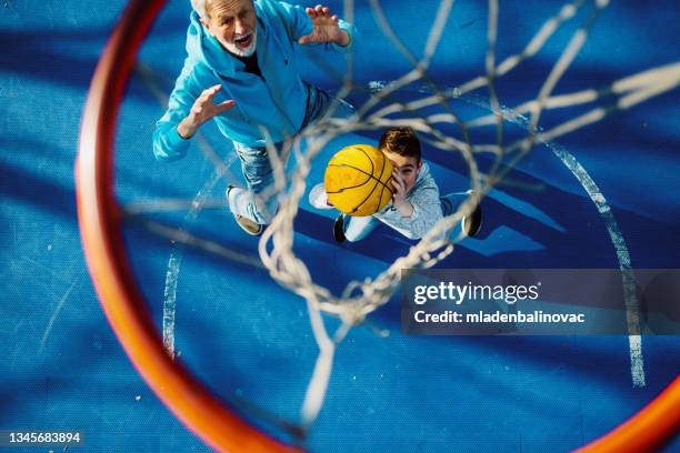 großvater und enkel - basketball teenager stock-fotos und bilder