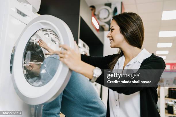 beautiful and happy young couple buying in modern appliances store. - appliance shop stock pictures, royalty-free photos & images