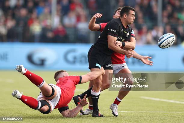 Alex Lozowski of Saracens offloads as Ben Stevenson and Callum Chick of Newcastle challenge during the Gallagher Premiership Rugby match between...