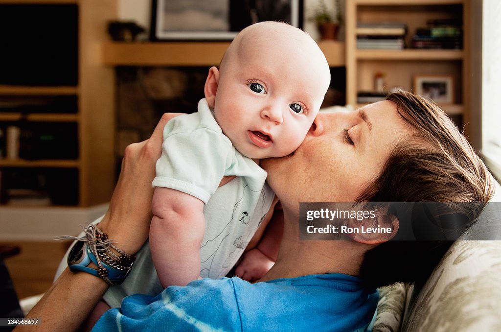 Infant boy being kissed by mother