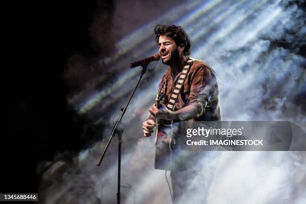 man singing and playing the guitar in front of the microphone - zangeres stockfoto's en -beelden