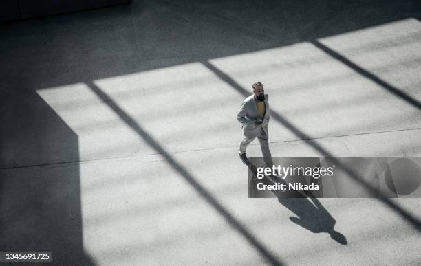 vue à angle élevé d’un homme d’affaires marchant à l’extérieur - business man modern city photos et images de collection