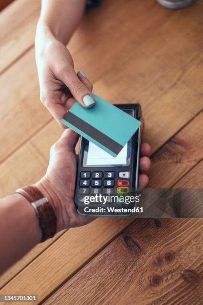 woman paying through credit card in restaurant - pagamento sem contacto imagens e fotografias de stock