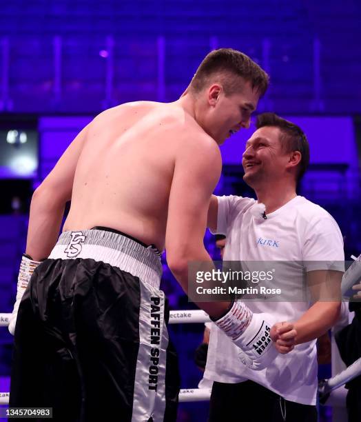 Viktor Jurk of Germany celebratw with his coach Christian Morales after the Heavyweight fight at GETEC-Arena on October 09, 2021 in Magdeburg,...