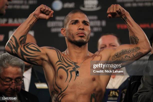 Miguel Cotto of Puerto Rico flexes his arms for the crowd on the scales ahead of his bout with Antonio Margarito of Mexico during their weigh in at...