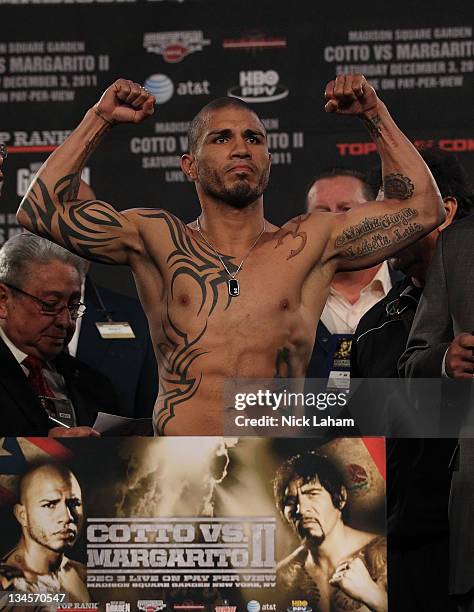 Miguel Cotto of Puerto Rico flexes his arms for the crowd on the scales ahead of his bout with Antonio Margarito of Mexico during their weigh in at...