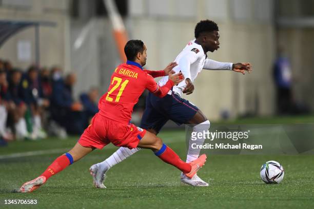 Bukayo Saka of England holds off Marc García of Andorra during the 2022 FIFA World Cup Qualifier match between Andorra and England at Estadi Nacional...
