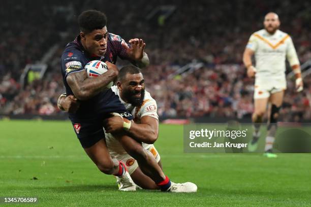 Julian Bousquet of Catalans Dragons attempts to tackle Kevin Naiqama of St Helens as they cross the line for their team's second try during the...