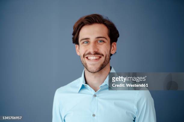 happy businessman against blue background - kopfbild stock-fotos und bilder