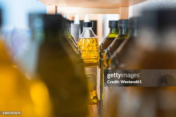 olive oil bottles on rack at store - oil bottle stock pictures, royalty-free photos & images