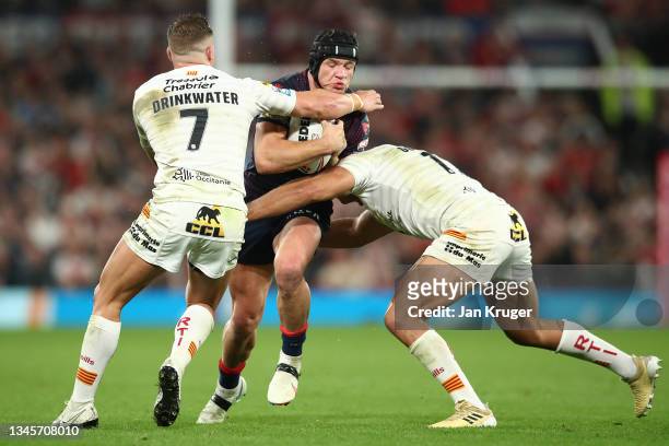 Jonny Lomax of St Helens is tackled by Josh Drinkwater and Mickael Goudemand of Catalans Dragons during the Betfred Super League Grand Final match...