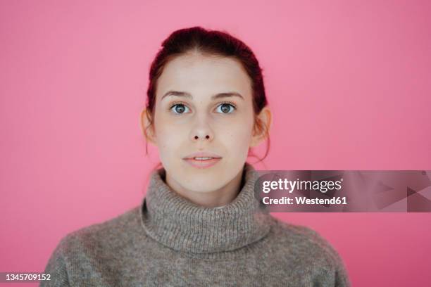 woman with blank expressions against pink background - polo neck stock pictures, royalty-free photos & images