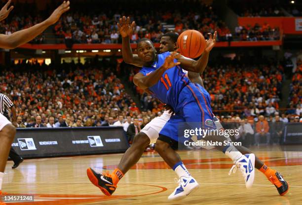 Erving Walker of the Florida Gators tries to pass the ball as he is chased by Dion Waiters of the Syracuse Orange during the game at the Carrier Dome...