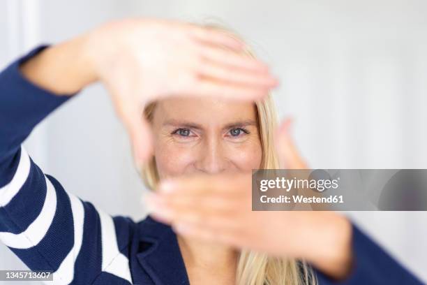 woman making finger frame at home - fingerrahmen stock-fotos und bilder