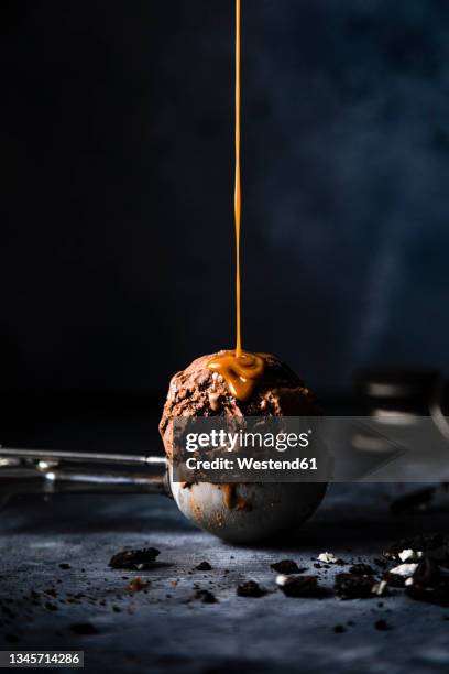 studio shot of caramel pouring on scoop of chocolate ice cream - 焦糖 個照片及圖片檔