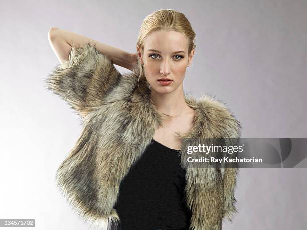 model with hand behind head wearing fur coat - mujer peluda fotografías e imágenes de stock