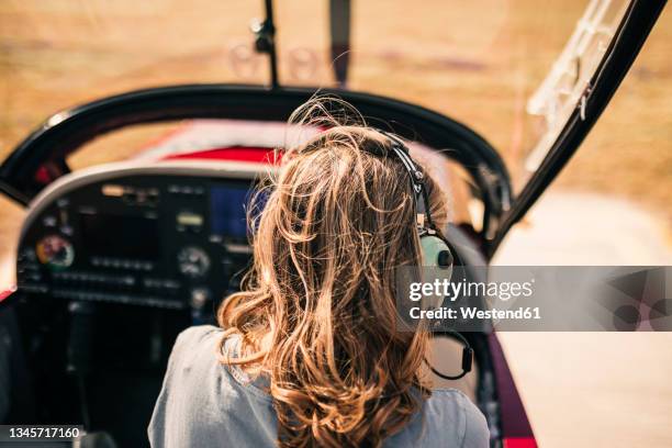 mature woman with blond hair sitting in airplane - female pilot stock-fotos und bilder