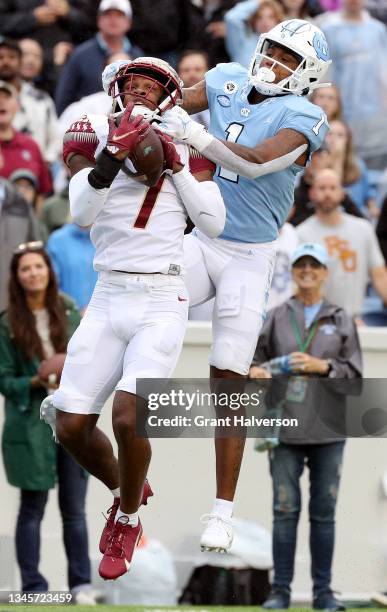 Jarrian Jones of the Florida State Seminoles intercepts a pass intended for Khafre Brown of the North Carolina Tar Heels during the first half of...