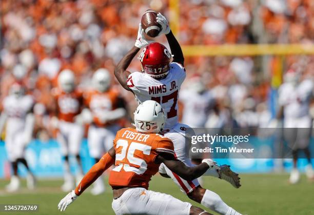 Marvin Mims of the Oklahoma Sooners catches a pass while defended by B.J. Foster of the Texas Longhorns in the second half during the 2021 AT&T Red...