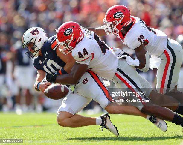 Bo Nix of the Auburn Tigers fumbles the ball as he is tackled by Travon Walker and Adam Anderson of the Georgia Bulldogs during the first half at...