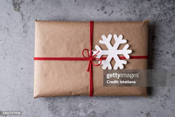 christmas present wrapped in brown paper - red bow stock pictures, royalty-free photos & images