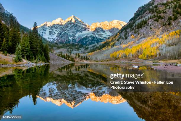 snowcapped maroon bells mountains with reflection and fall foliage aspen colors at sunrise - アスペン ストックフォトと画像