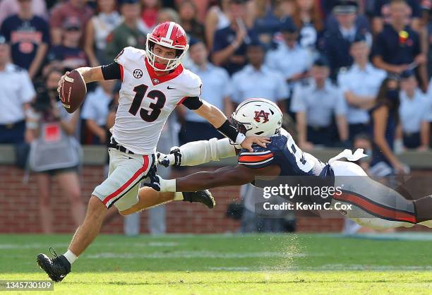 Stetson Bennett of the Georgia Bulldogs rushes away from Colby Wooden of the Auburn Tigers during the first half at Jordan-Hare Stadium on October...