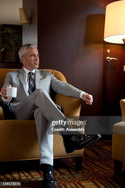 mature businessman sitting in private lounge - lounge chair bildbanksfoton och bilder