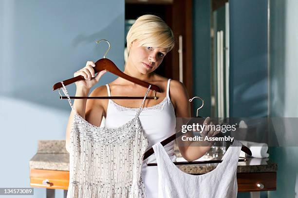 woman choosing an outfit to wear. - vestirse fotografías e imágenes de stock