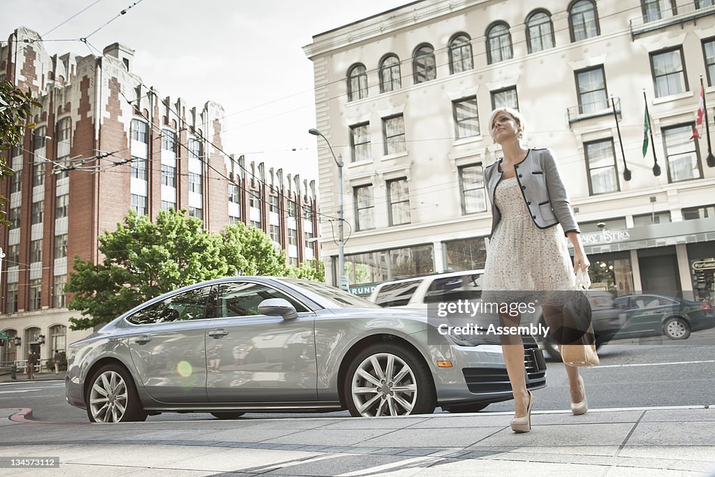 A woman parks her car downtown.