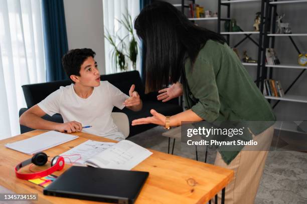 madre e suo figlio adolescente che discutono a casa - confrontation foto e immagini stock