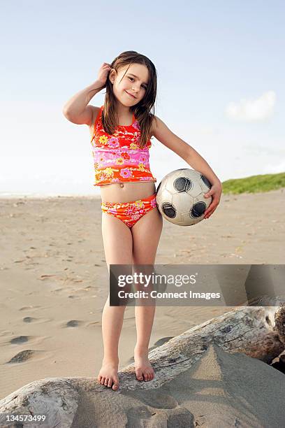 girl holding soccer ball at beach - young girl swimsuit stockfoto's en -beelden