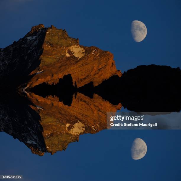 abstract image of the top of a mountain with the moon and the evening sky - parc national de gran paradiso photos et images de collection